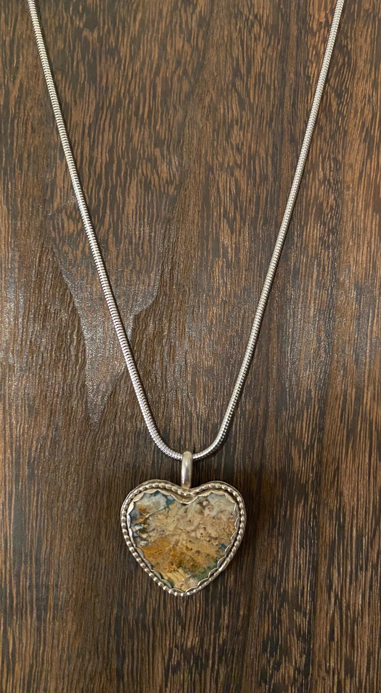 Heart shaped pendant with plume agate stone